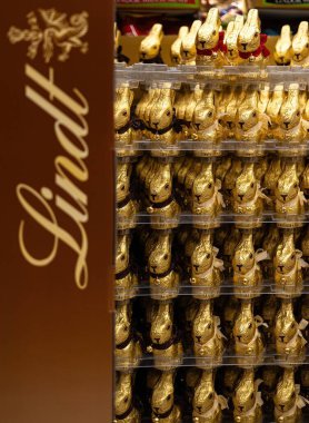 Bir yığın altın renkli Lindt tavşanı büyüleyici cazibeleri ve enfes zevkleriyle çok güzel müşteriler sergilediler. - FRANKFURT, Almanya - 21 Mart 2025