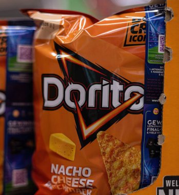 Bu resim, Doritos nacho peynirli atıştırmalık paketlerini perakende rafında belirgin bir şekilde sergiliyor, parlak ambalajlarını ve abur cubur aşıkları için karşı konulmaz çekiciliklerini sergiliyor. - FRANKFURT, Almanya - 21 Mart 2025