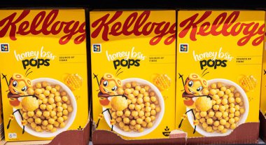 Kellog 'un ballı gevreğinden oluşan parlak ve neşeli bir kutu mısır gevreği, eğlenceli bir karakter tasarımı sergiliyor, keyifli bir kahvaltı deneyimi için enerji ve neşe somutlaştırıyor. - FRANKFURT, Almanya - 21 Mart 2025