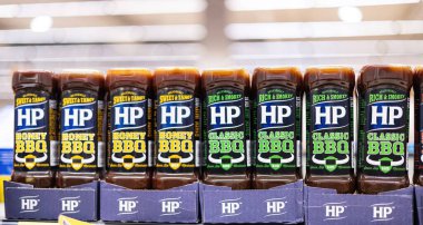 Sergideki cesur HP baharatlı barbekü sosu şişeleri ızgara meraklıları ve yemeklerini sevenler için mükemmel bir lezzet deneyimi vaat ediyor. - FRANKFURT, Almanya - 21 Mart 2025