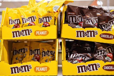 Fıstık MandM 'ler sergilenen parlak sarı ambalaj düzeneği, bu popüler, sevilen şeker şekerinin oyuncu karakterini ve markasını gözler önüne seriyor. - FRANKFURT, Almanya - 21 Mart 2025