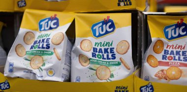 Tuc Mini kek rulolarının renkli bir çeşidi farklı tatlar sergiliyor, canlı bir market ortamında dikkat çekiyor. - FRANKFURT, Almanya - 21 Mart 2025