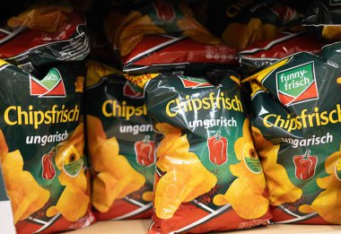 Canlı bir cips torbası gösterisi, farklı tatlar ve tasarımlar sergileniyor bir markette abur cubur aşıkları için. - FRANKFURT, Almanya - 21 Mart 2025