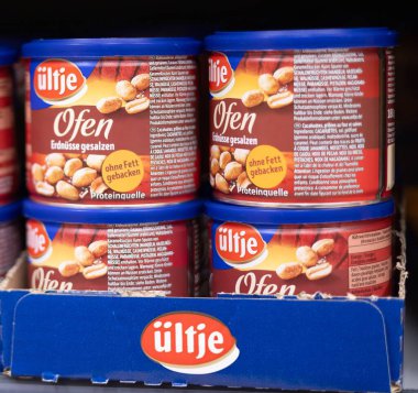 Mavi ambalajlı kavrulmuş tuzlu fıstıklardan oluşan görsel olarak cazip bir düzenleme aperatif cazibesini ve tadını ön plana çıkarıyor. - FRANKFURT, Almanya - 21 Mart 2025