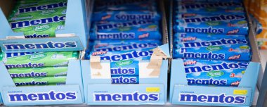 Market raflarında düzenlenmiş canlı bir dizi Mentos şekeri, şeker severlerin tazelik arzusunu tatmin etmeye hazır. - FRANKFURT, Almanya - 21 Mart 2025