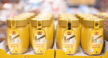 Yüksek kaliteli bal ürünlerinin doğal tatlılığını ve saflığını vurgulayan kremalı Langnese bal kavanozlarıyla dolu bir raf. - FRANKFURT, Almanya - 21 Mart 2025