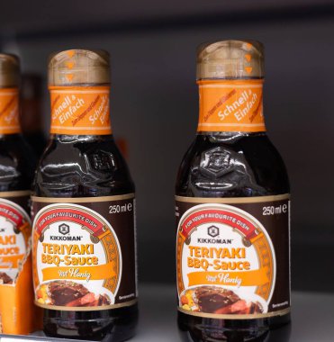 İki şişe Kikkoman 's teriyaki barbekü sosu, ızgara meraklıları için mükemmel bir füzyon, bir mağaza rafında güzelce sergileniyor. - FRANKFURT, Almanya - 21 Mart 2025