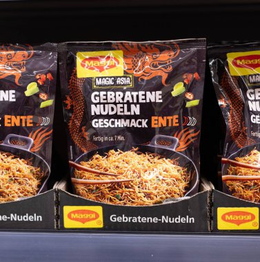 Bu resimde ördek aromalı kızarmış şehriye paketi var. Canlı markalar sergiliyor ve büyüleyici görüntüler sergiliyor. - FRANKFURT, Almanya - 21 Mart 2025