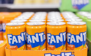 Bir perakende mağazasında canlı renkler ve marka kimliğiyle düzgünce istiflenmiş Fanta portakallı soda kutularının çekici bir gösterisi. - FRANKFURT, Almanya - 21 Mart 2025