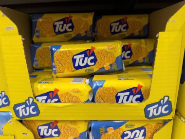 Parlak renkli Tuc krakerleri bir mağaza rafına güzelce yerleştirilmiş, çekici ambalaj ve lezzet çeşitliliklerini sergiliyorlar. - FRANKFURT, Almanya - 21 Mart 2025