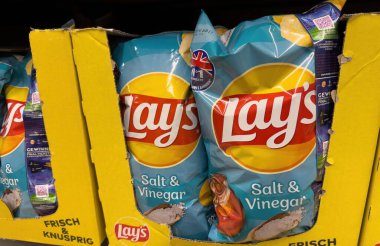 Tuz ve sirke cipslerini belirgin bir şekilde özel ambalajlarında sergiliyor, keskin atıştırmalık hayranlarına çekici geliyor. - FRANKFURT, Almanya - 21 Mart 2025