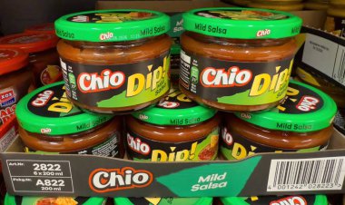 Chio soslu sos kavanozları düzgünce istiflenmiş, arkadaşlar arasında atıştırmalık ve toplanma için ideal lezzetleri sergiliyorlar. - FRANKFURT, Almanya - 21 Mart 2025