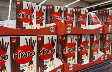 Bir süpermarket rafına istiflenmiş Mikado atıştırmalık kutularının göz alıcı bir gösterisi. Çekici paketlerini ve çeşitliliklerini sergiliyorlar. - FRANKFURT, Almanya - 21 Mart 2025