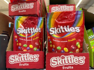 Renkli Skittles meyve ambalajları mağazalarda belirgin bir şekilde sergileniyor, müşterileri lezzetlerin gökkuşağını tatmaya davet ediyor. - FRANKFURT, Almanya - 21 Mart 2025