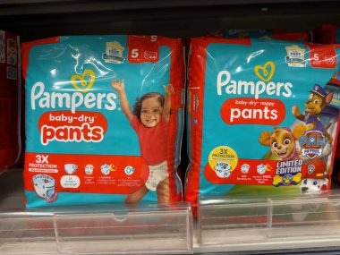 Bebek bezi kuru pantolonlar, kuru ve rahat bebek bezi deneyiminin faydalarını gösterirken yeni yürümeye başlayan bir çocuğun gülümsemesini içerir. - FRANKFURT, Almanya - 21 Mart 2025