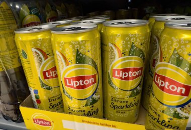 Parlak sarı tasarımı ve ferahlatıcı lezzet seçeneklerini sergileyen canlı bir Lipton limonata kutusu gösterisi. - FRANKFURT, Almanya - 21 Mart 2025