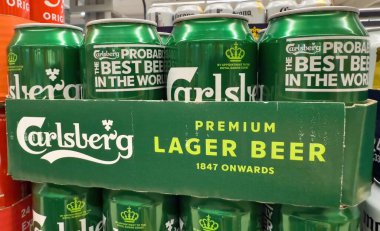 Bir yığın canlı yeşil Carlsberg bira kutuları, arkadaşlar arasında günlük toplantılara ve sosyal eğlenceye davetiye çıkarıyor. - FRANKFURT, Almanya - 21 Mart 2025