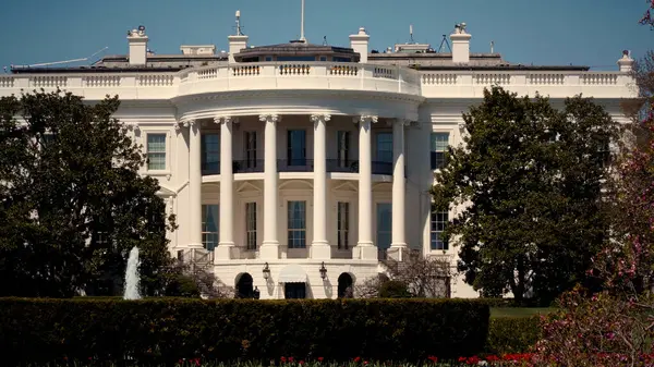 WASHINGTON DC, ABD - Nisan 08, 2017 - Washington DC 'de güneşli bir günde, ön planda çiçekler ve ağaçlar açan Beyaz Saray güney cephesi