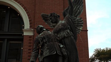 VANCOUVER, CANADA - 11 Nisan 2017 - Kanada, Vancouver 'daki Zafer Meydanı Cenotaph savaş anıtında ölen asker heykelini rahatlatan melek heykeli