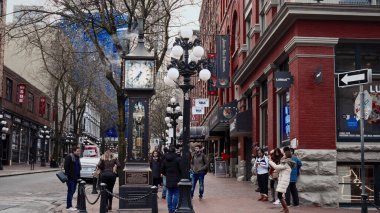 VANCOUVER, CANADA - 11 Nisan 2017 - Gastown, Vancouver 'daki buhar saatinin yanında yürüyen ve fotoğraf çeken turistler
