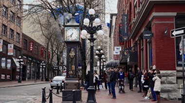 VANCOUVER, CANADA - 11 Nisan 2017 - İnsanlar Vancouver 'ın tarihi Gastown bölgesindeki ikonik buhar saatinin etrafında toplanıyor