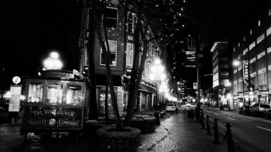 VANCOUVER, CANADA - 11 Nisan 2017 - Vancouver Tramvay Şirketi 'nin aracının siyah beyaz fotoğrafı Gastown' da Water Caddesi 'ne park edilmiş, ağaçlar ve binalar şenlikli ışıklarla süslenmiş