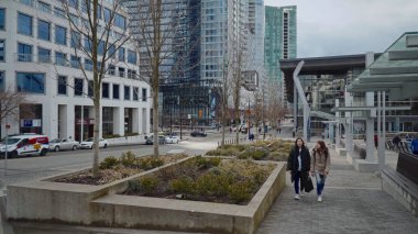 VANCOUVER, CANADA - 11 Nisan 2017 - Kanada yakınlarındaki bir kaldırımda yürüyen iki öğrenci Vancouver, British Columbia