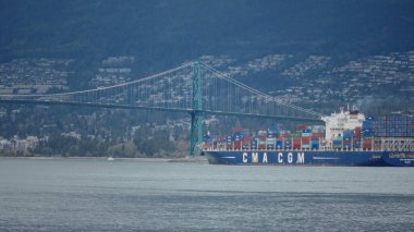 VANCOUVER, CANADA - 11 Nisan 2017 - İngiliz Kolombiya Kolumbiyası, Vancouver 'da Lions Gate Köprüsü altında yelken açan büyük konteyner gemisi