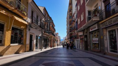 İspanya 'nın Ronda kentindeki yaya sokağı Calle de la Bola' da yürüyen turistler, dükkanları ve balkonları - RONDA, SPAIN - 28 Mart 2025