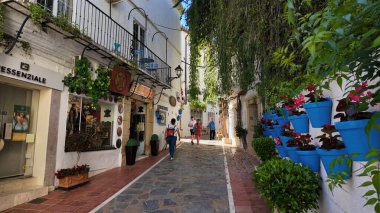 Marbella, İspanya 'da, Marbella, İspanya' da dar bir kaldırım taşı sokakta yürüyen turistler 30 Mart 2025
