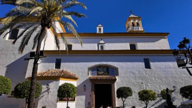 Marbella, İspanya 'da palmiye ağacı ve mavi gökyüzü olan Ermita del Santo Cristo de Marbella Kilisesi' nin beyaz cephesi - MARBELLA, SPAIN - 30 Mart 2025