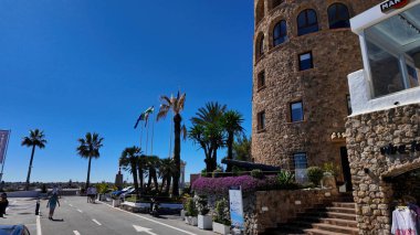 Güneşli bir günde Puerto Deportivo de Marbella 'nın yakınlarında yürüyen turistler - MARBELLA, İspanya - 30 Mart 2025