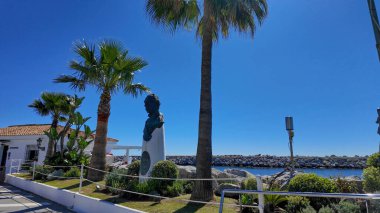 Puerto Banus 'un kurucusu Jose Banus' un iflası, güneşli bir günde Marbella, İspanya 'da palmiye ağaçları ve mavi gökyüzü - MARBELLA, İspanya - 30 Mart 2025