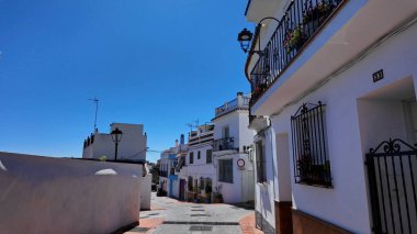 İspanya 'nın Marbella şehrinde dar bir sokakta sıralanan geleneksel beyaz boyalı binalar, karakteristik Endülüs mimari tarzını gözler önüne seriyor - MARBELLA, SPAIN - 30 Mart 2025
