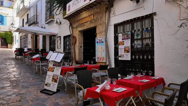 Marbella, İspanya 'da bir restoranda müşterileri davet eden kırmızı masa örtüleriyle açık masa masaları - MARBELLA, SPAIN - 30 Mart 2025
