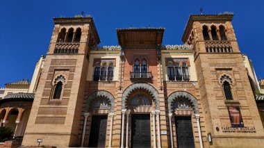 Güneşli bir günde Sevilla, İspanya 'da yer alan Endülüs mimarisine sahip güzel bir bina olan mudejar köşkünün düşük açılı görüntüsü - SEVILLE, SPAIN - 25 Mart 2025