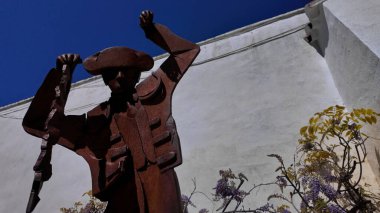 Geleneksel kıyafetler ve şapkayla İspanya 'nın Ronda kentinde zafer kutlayan bir boğa güreşçisinin paslı heykeli - RONDA, İspanya - 28 Mart 2025