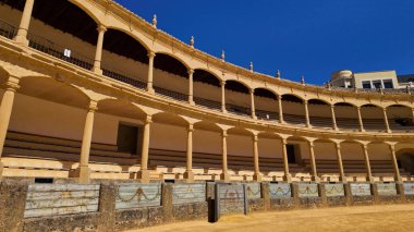 Ronda 'nın açık mavi gökyüzü ile simgesel arenasının güneşli manzarası - RONDA, SPAIN - 28 Mart 2025