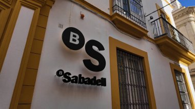 Sabadell Bankası şube levhasında Sevilla, İspanya 'da beyaz ve sarı bir cephede logosu görülüyor - SEVILLE, SPAIN - 25 Mart 2025