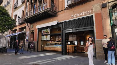 İspanya, Sevilla 'da bir dondurma dükkanının önünde yürüyen insanlar - SEVILLE, SPAIN - 25 Mart 2025