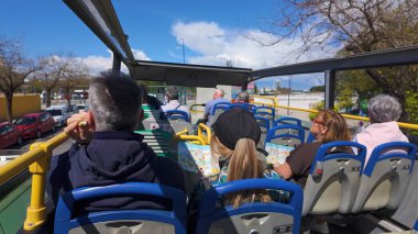 Güneşli bir günde İspanya 'nın Seville kentindeki otobüs turunun tadını çıkaran turistler, şehrin simgelerini - SEVILLE, SPAIN - 25 Mart 2025