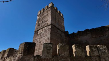 Macarena Seville, İspanya 'da tarihi bir taş kule manzarası, açık mavi gökyüzüne karşı ortaçağ mimarisini vurguluyor - SEVILLE, SPAIN - 25 Mart 2025