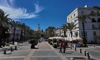 Güneşli bir günde İspanya 'nın Cadiz kentindeki Plaza de San Juan de Dios açık hava pazarında yürüyen ve alışveriş yapan insanlar - CADIZ, SPAIN - 26 Mart 2025