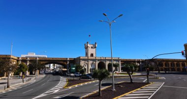 Puerta de Tierra, İspanya 'nın Cadiz şehrindeki canlı mavi gökyüzüne karşı dimdik ayakta duruyor. Şehrin zengin tarihi ve mimari hünerinin bir kanıtı. CADIZ, SPAIN - 26 Mart 2025