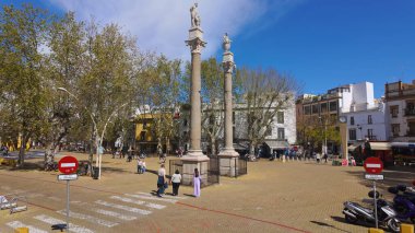 Alameda de Herkül Meydanı, Seville, İspanya 'da güneşli bir günün tadını çıkaran insanlar, antik Roma sütunları SEVILLE, SPAIN - 25 Mart 2025