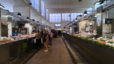 İspanya 'nın Cadiz şehrinde bulunan ünlü bir pazar yeri olan Mercado Central de Abastos' taki müşterilere deniz ürünleri satan balıkçılar - CADIZ, SPAIN - 26 Mart 2025