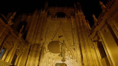 Gece aydınlatılan Sevilla Katedrali 'nin alçak açılı görüntüsü gotik mimariyi gözler önüne seriyor - SEVILLE, SPAIN - 25 Mart 2025