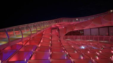 Metropol Şemsiyesi 'nin modern mimarisi, İspanya' nın Sevilla şehrinde geceleyin mor ve mavi ışıklarla parlayan SEVILLE, SPAIN - 25 Mart 2025