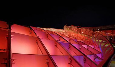 İspanya 'nın Sevilla kentindeki Metropol Şemsiyesi' nin gelecekteki ahşap yapısı gece canlı renklerle parlayarak çarpıcı bir şehir manzarası yaratıyor - SEVILLE, SPAIN - 25 Mart 2025