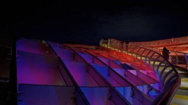Metropol Şemsiyesi 'nin modern mimarisi, İspanya' nın Sevilla şehrinde geceleyin mor ve mavi ışıklarla parlayan SEVILLE, SPAIN - 25 Mart 2025
